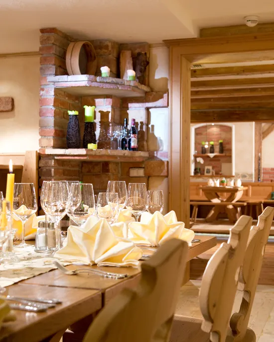 Rustikaler Restaurant-Speiseraum mit Holzmöbeln, gefalteten Servietten und gedeckten Weingläsern